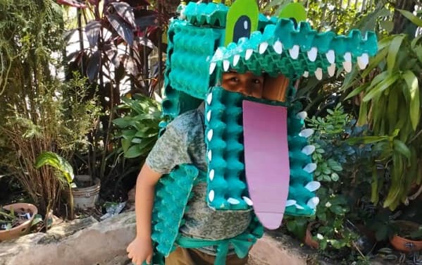 Niño diseña disfraz de cocodrilo con materiales reciclados